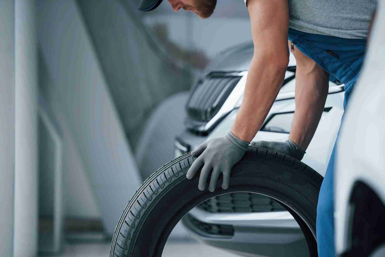 Mechanic holding a tyre at Jackson's Tyres garage.