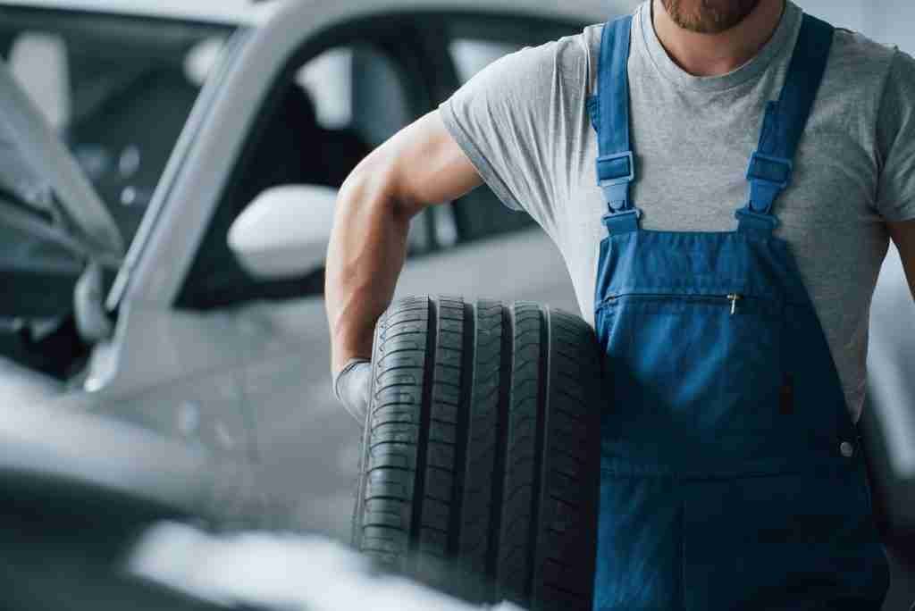 Jackson's Tyres mechanic holding a tyre